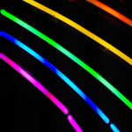 Regenbogenfarbene Neonleuchten vor dunklem Hintergrund