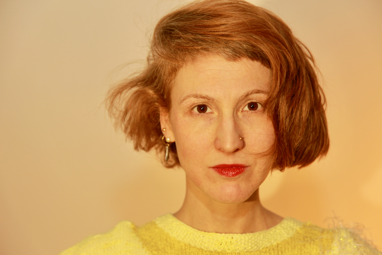 A portrait photo of Kerstin in a yellow sweater